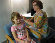 Photo of audiologist checking Abby's hearing