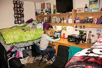 a MSUB student studying in her residence hall romom