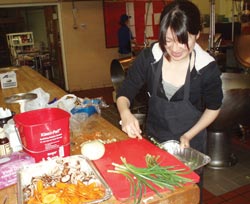 student prepares vegetables for a dish at the MSUB International Food Fair 2009