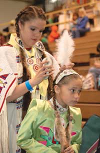 a photo of two girls getting ready for their Powwow dances