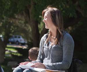 a freshman student relaxes outside on the MSUB University campus