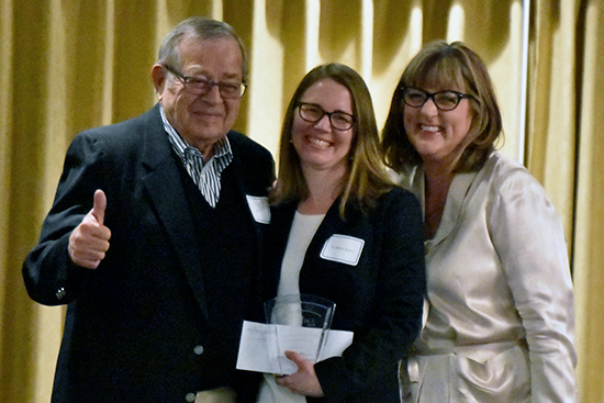 Dr. Melissa Boehm, assistant professor of communications, is presented with the Winston and Helen Cox Fellowship Award during the annual Faculty Excellence award banquet by the Cox Family, right, and College of Arts and Sciences Dean Christine Shearer, left
