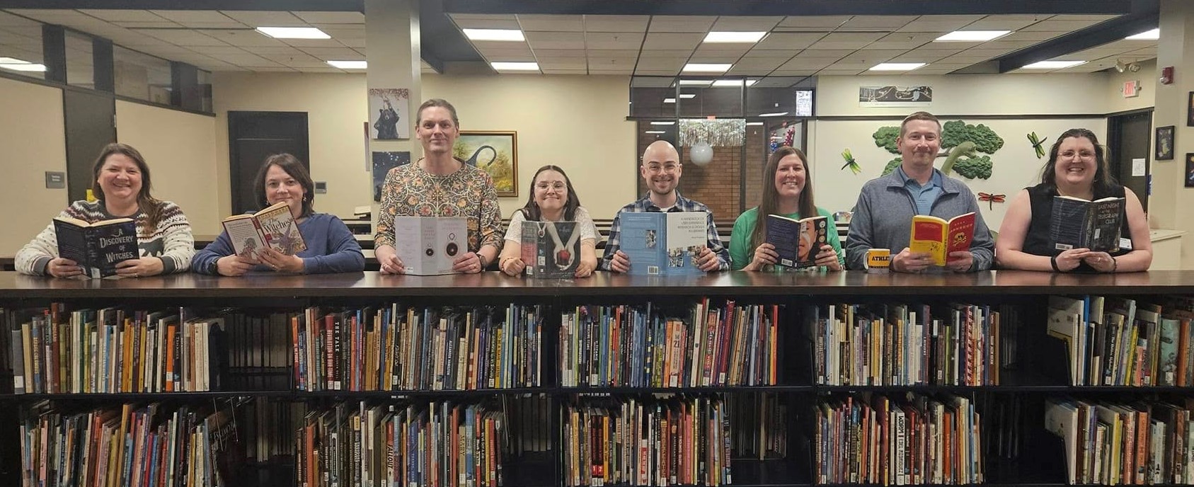 Library staff posing with books