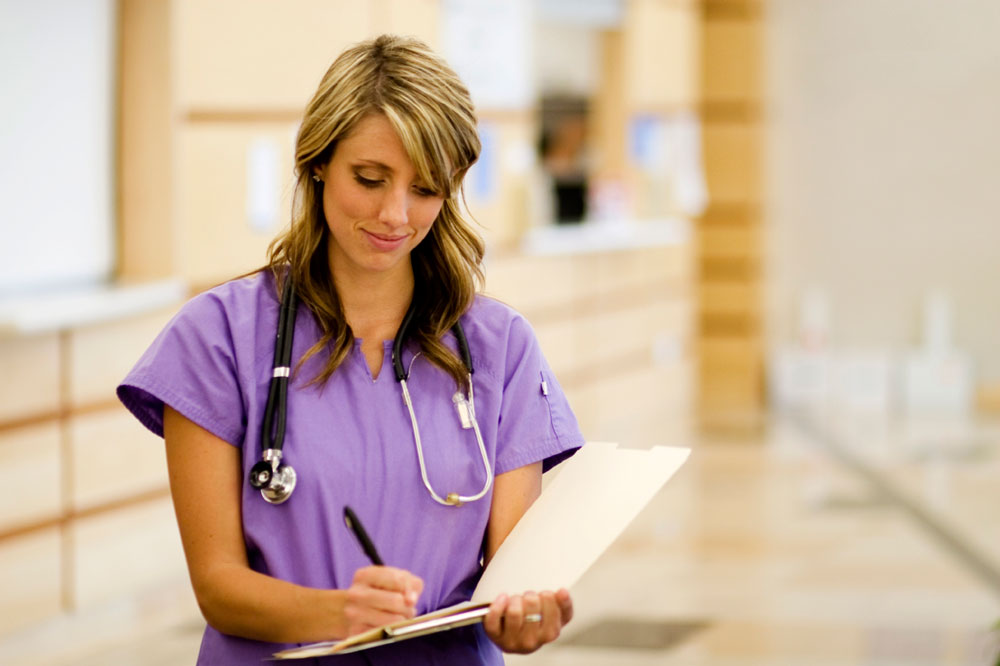 nurse writing on clipboard