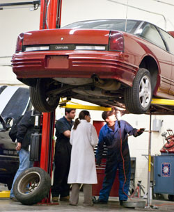 auto repair students listen to their instructor in a lab at the COT