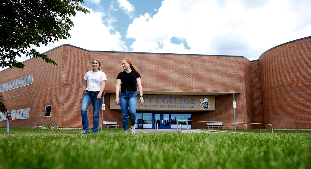 two students standing in front of Tech Building