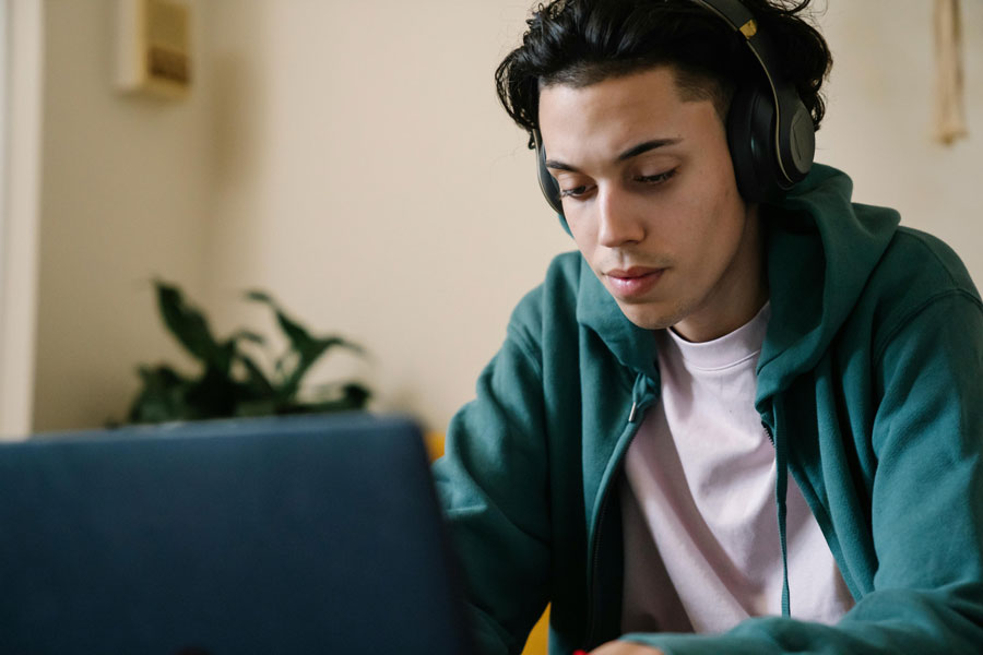Teen with headphones using a laptop