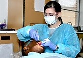a dental hygienist treating a patient