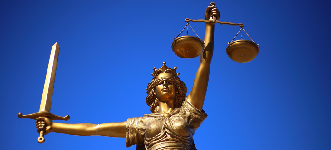 Lady Justice holds a sword in one hand and scales in the other