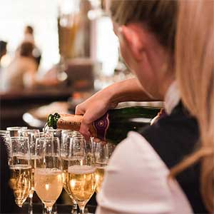 wait staff pouring a glass of champagne