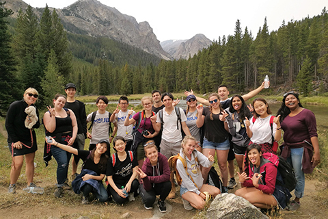 A group of students pose in front of a mountain