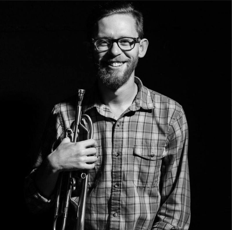 Zach Lange smiling & holding trumpet