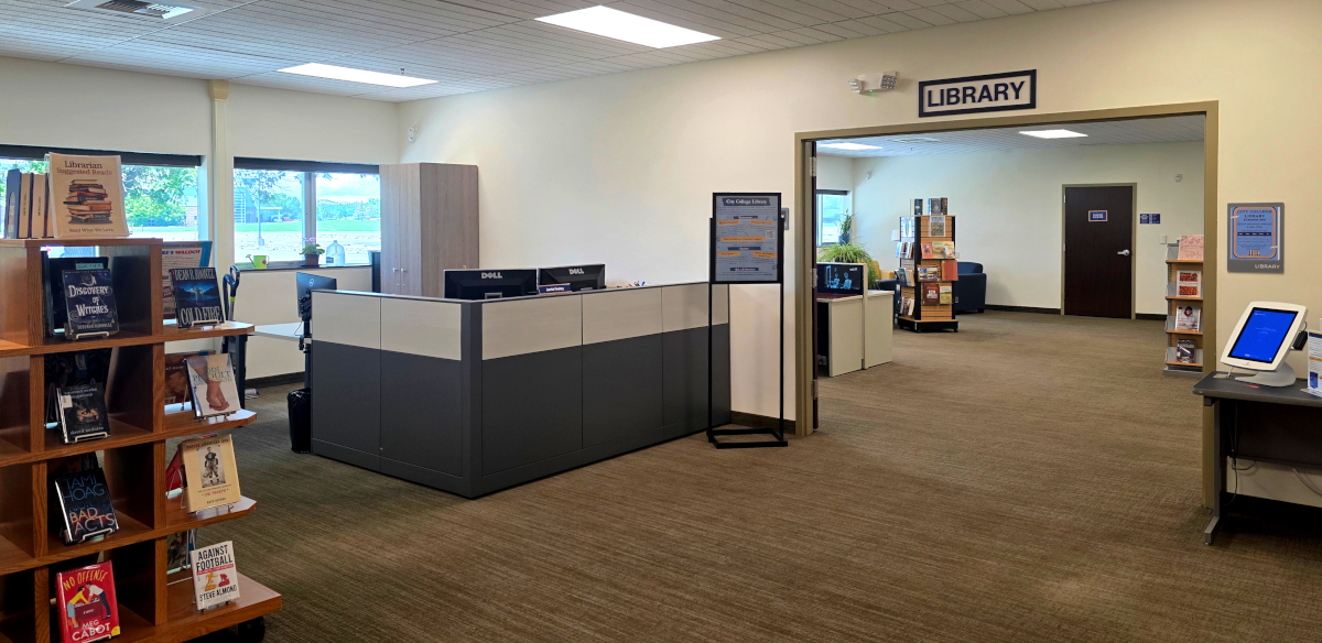 A carpeted room with seating, computer desks, and wide windows.