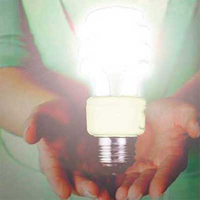hands holding an illuminated lightbulb