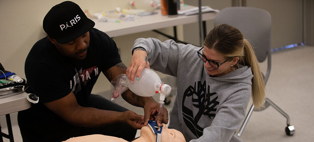 Paramedic students work with a dummy