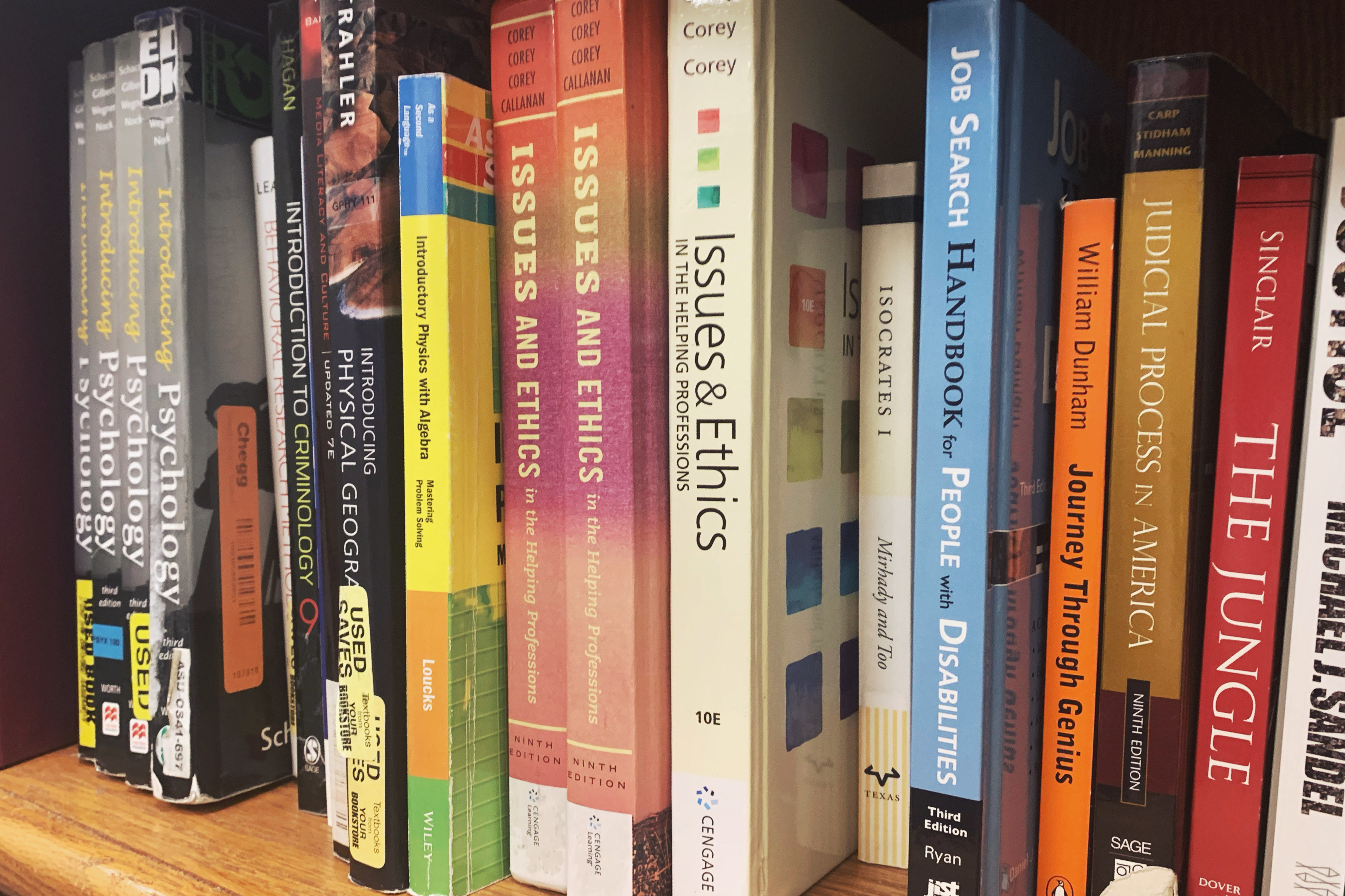 Books on a shelf; titles like "Issues and Ethics" can be seen.