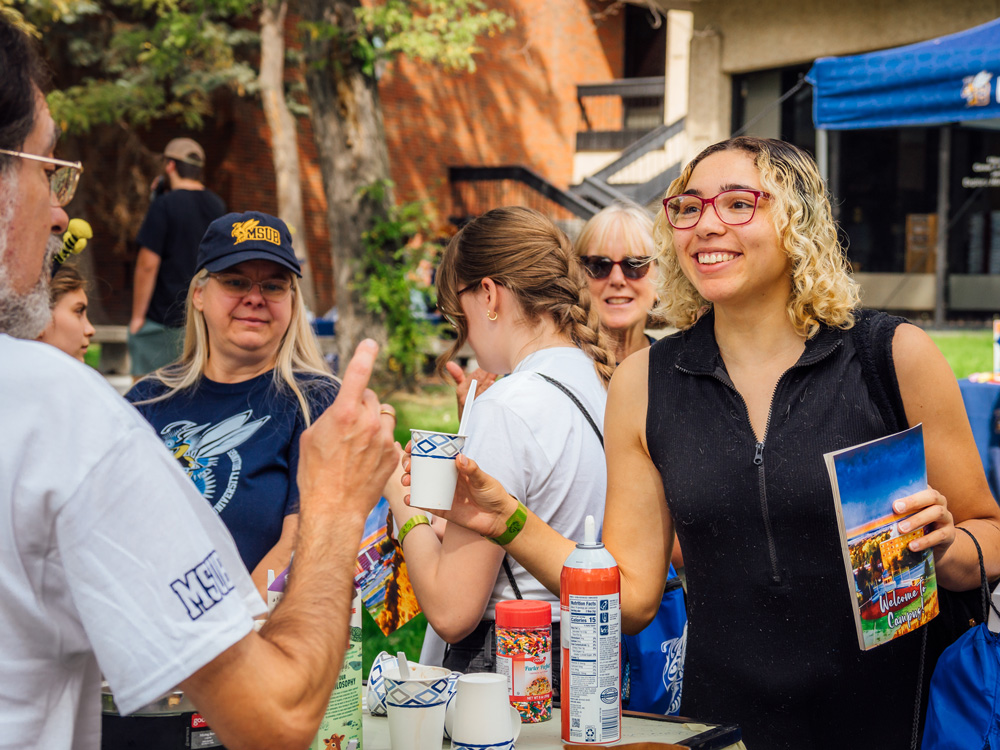 student gets ice cream sundae from info table